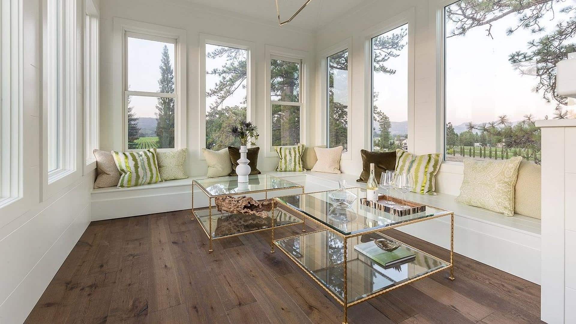 Bright sunroom with windows and glass tables.